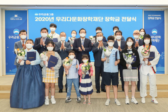 우리금융그룹 우리다문화장학재단은 30일 서울 중구 우리은행 본점에서 '2020년 다문화 학생 장학금 전달식'을 갖고 다문화 장학생 430명에게 총 6억 3000만원의 장학금을 전달했다. 이날 행사에서 손태승 우리금융그룹 회장(가운데)  겸 우리다문화장학재단 이사장과 이사진, 장학생 대표 12명이 기념촬영을 하고있다. <우리금융그룹 제공>